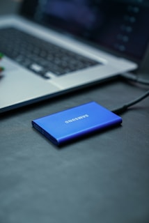 A samsung power bank sitting on a desk next to a laptop