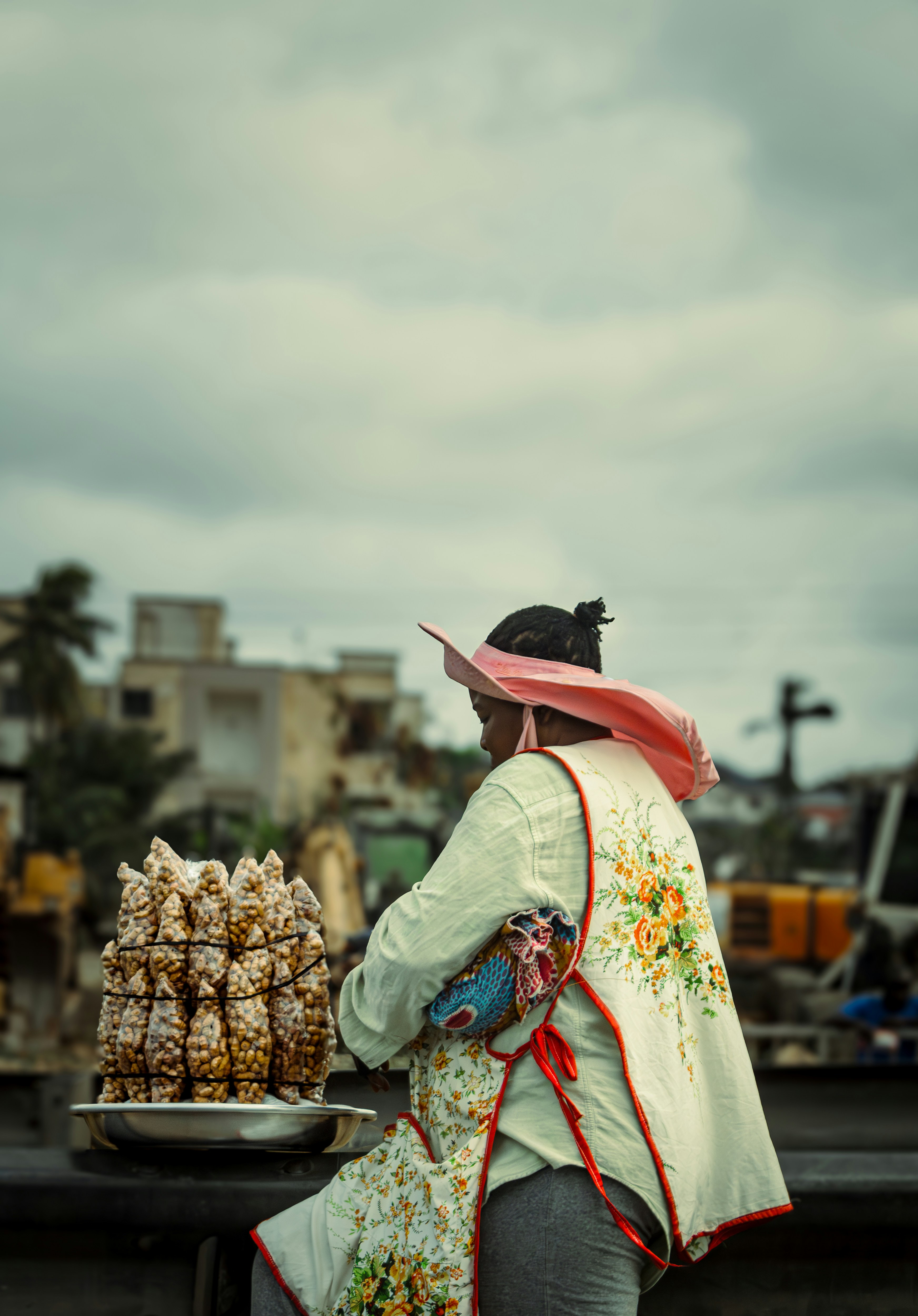 A woman walking down a street past a street vendor