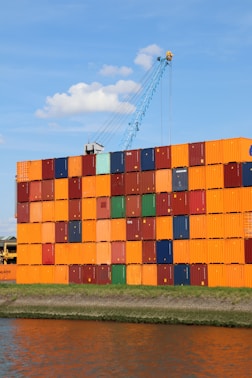 A large orange container sitting next to a body of water