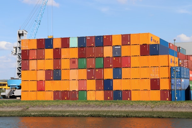 A large stack of containers sitting next to a body of water