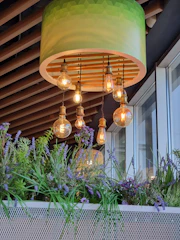 A green lamp hanging from a wooden ceiling