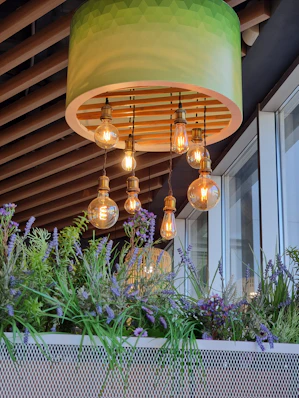 A green lamp hanging from a wooden ceiling