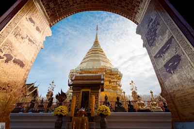 An arch leading into a temple with a sky in the background