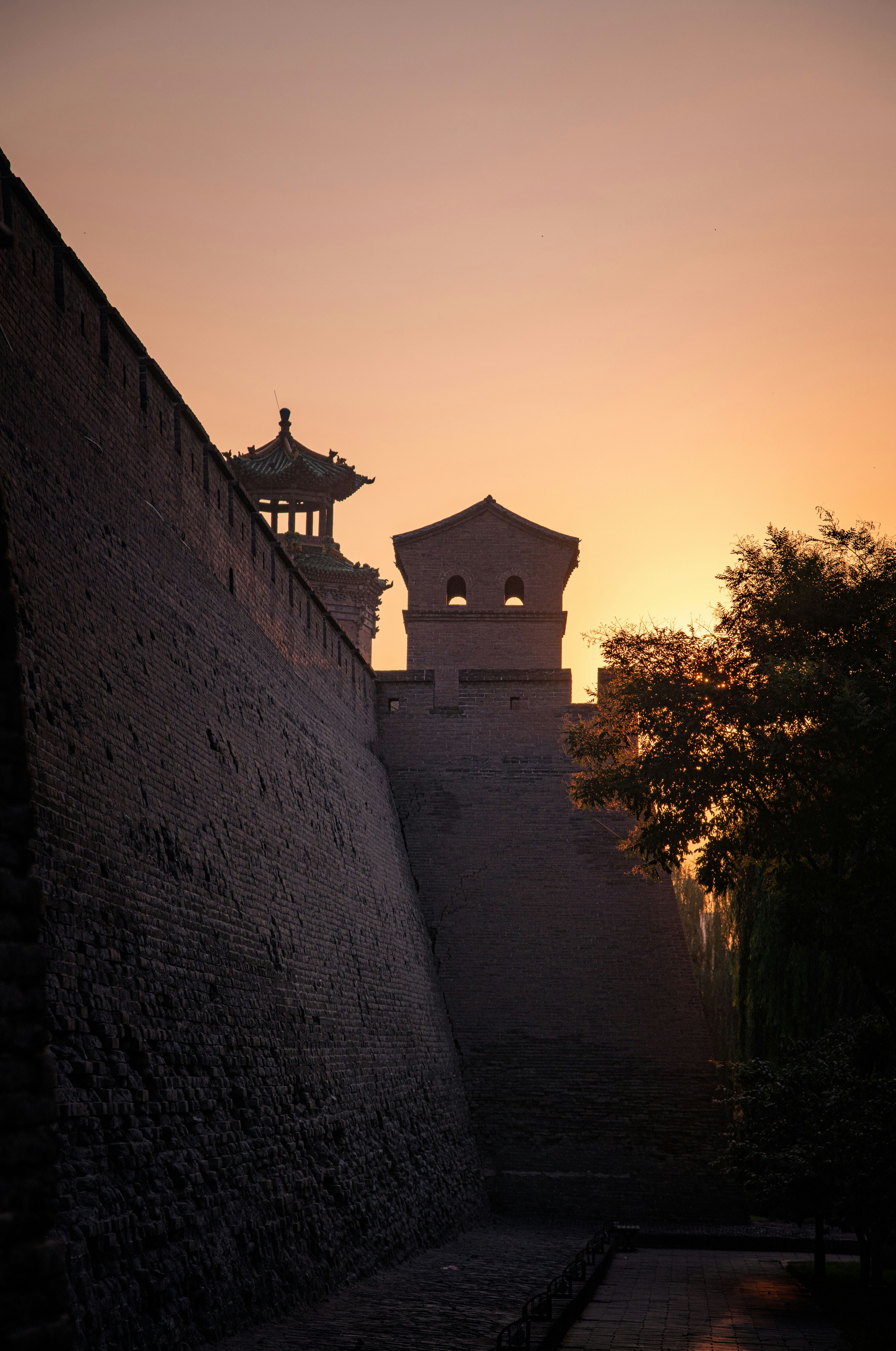 鐘楼のある壁の向こうに太陽が沈んでいます