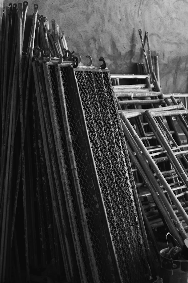 A pile of skis sitting next to a wall