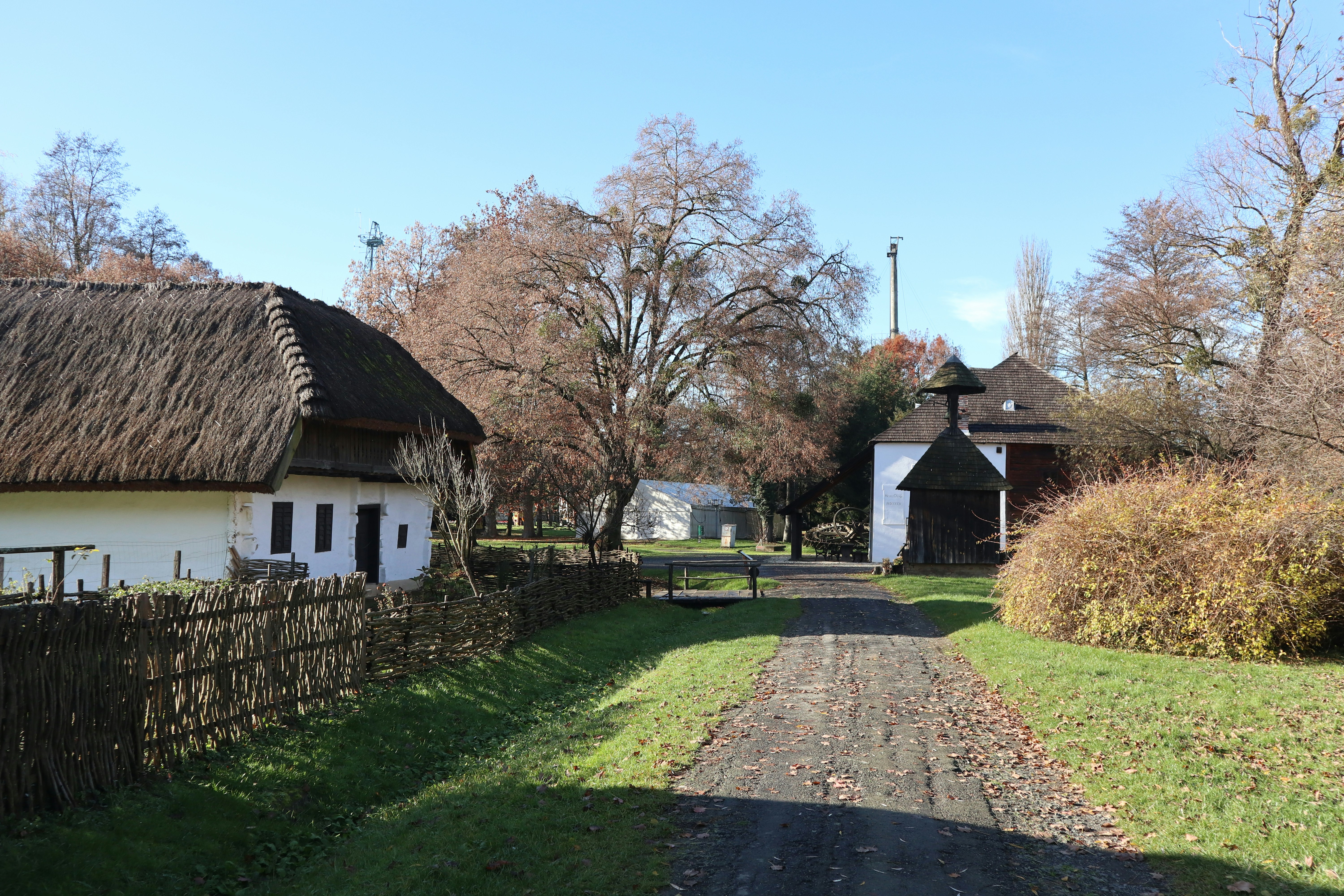 A dirt road leading to a white house