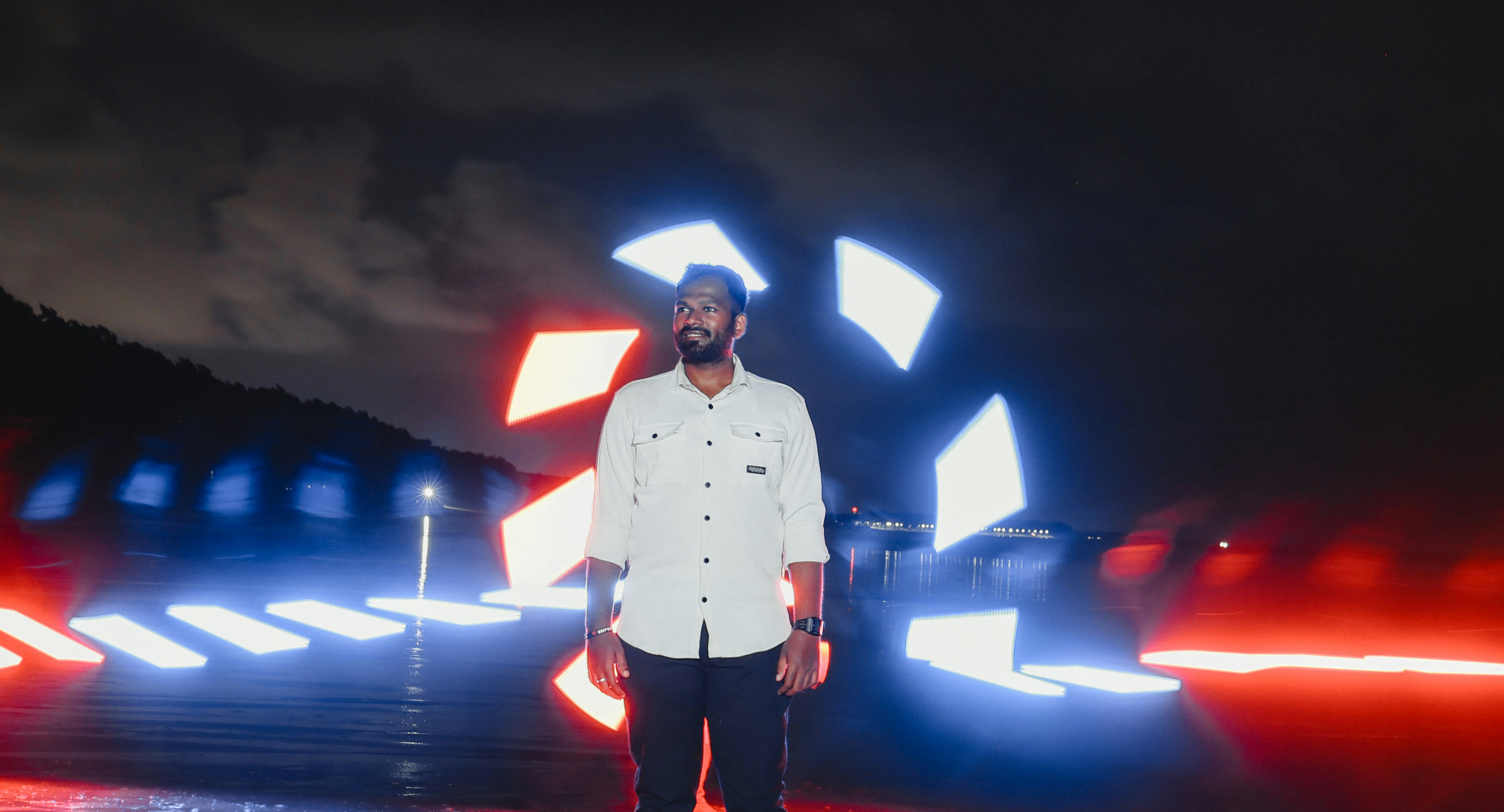 A man standing in front of a red and blue light