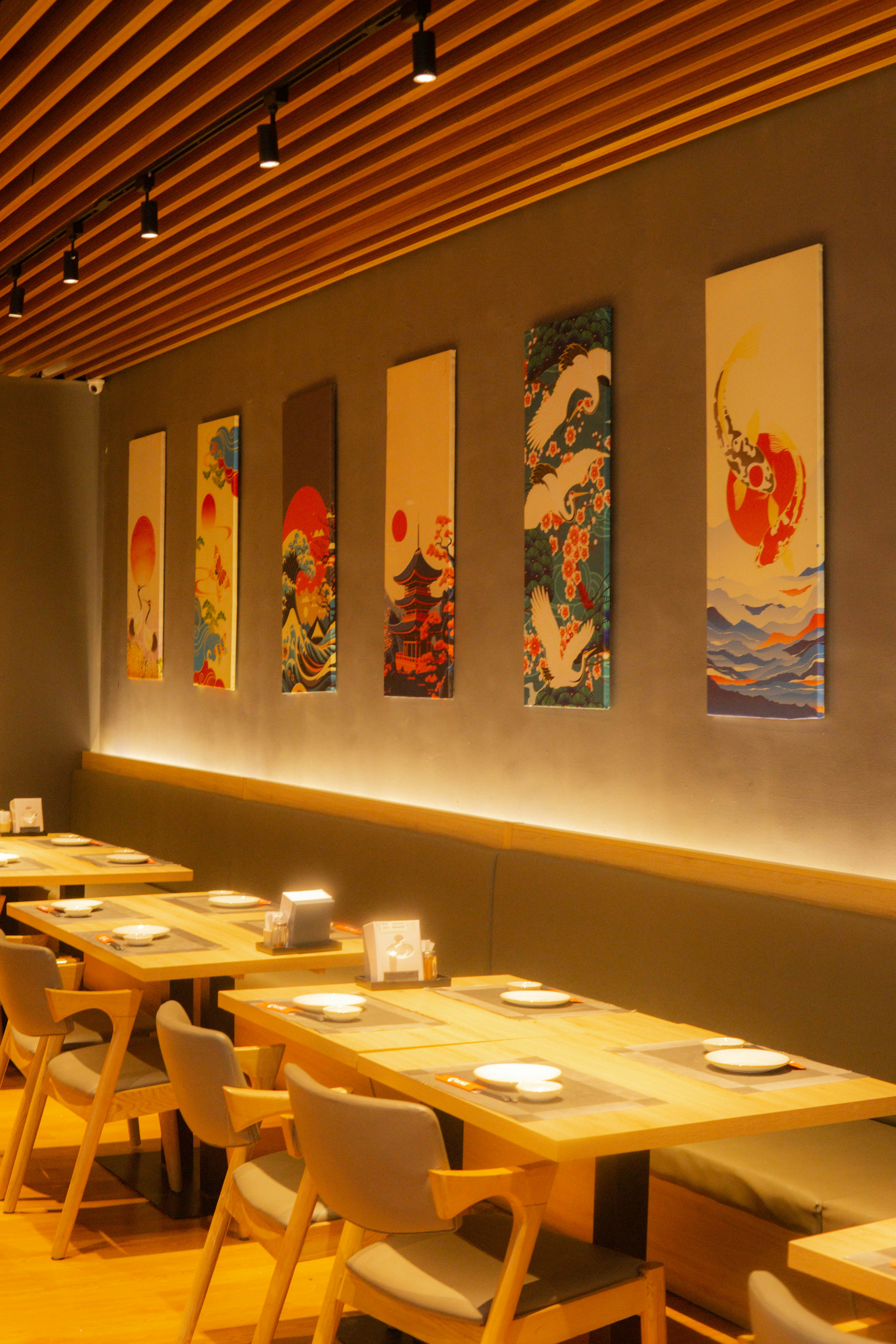 A restaurant with tables and chairs and paintings on the wall