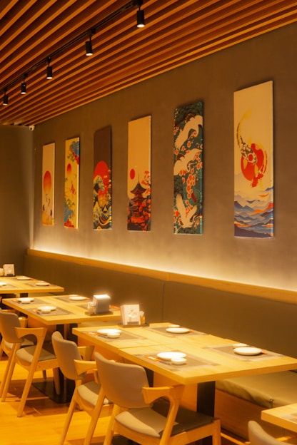 A restaurant with tables and chairs and paintings on the wall