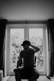 A man sitting on a chair in front of a window