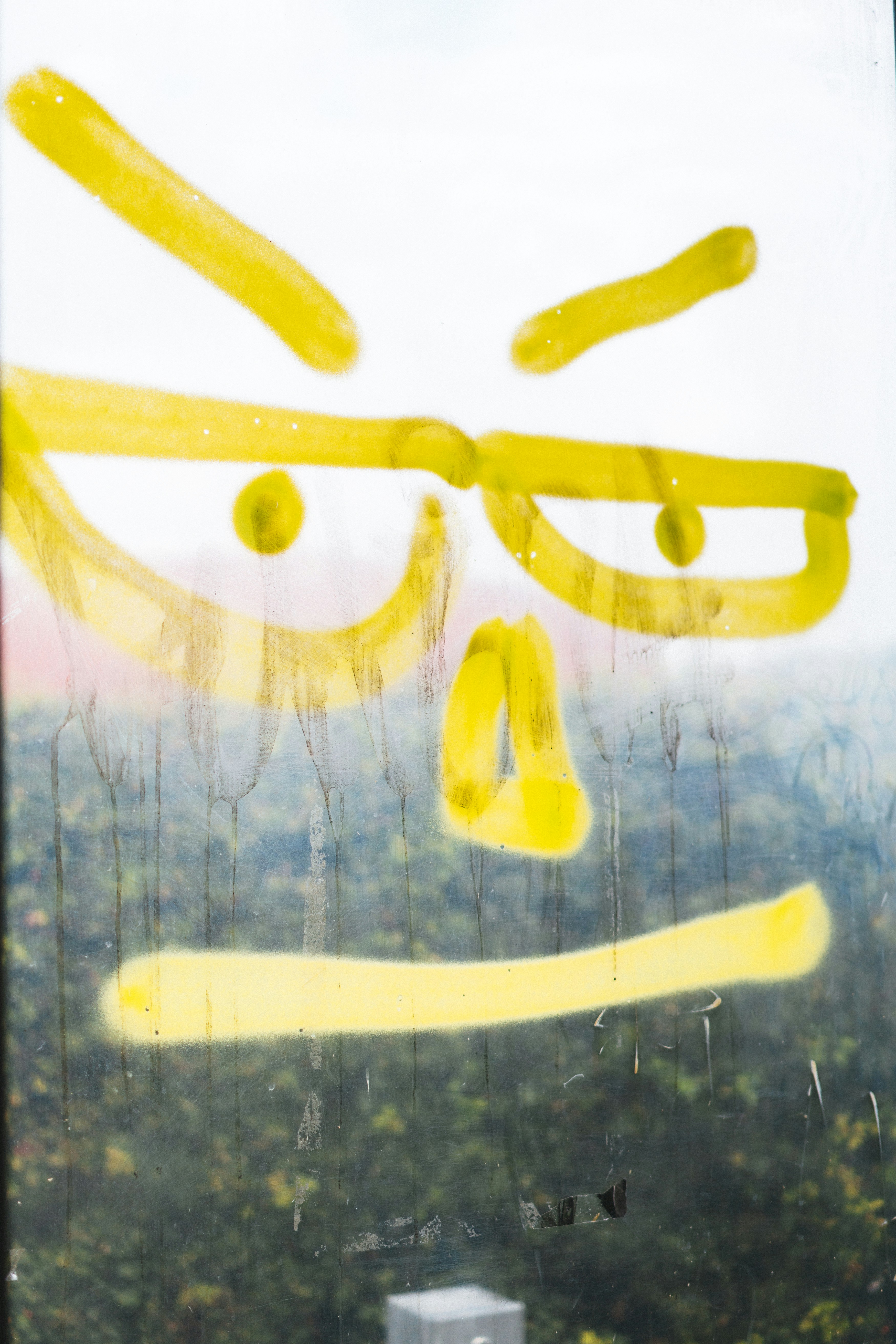 Ein Fenster mit einem gelben Smiley darauf gemalt