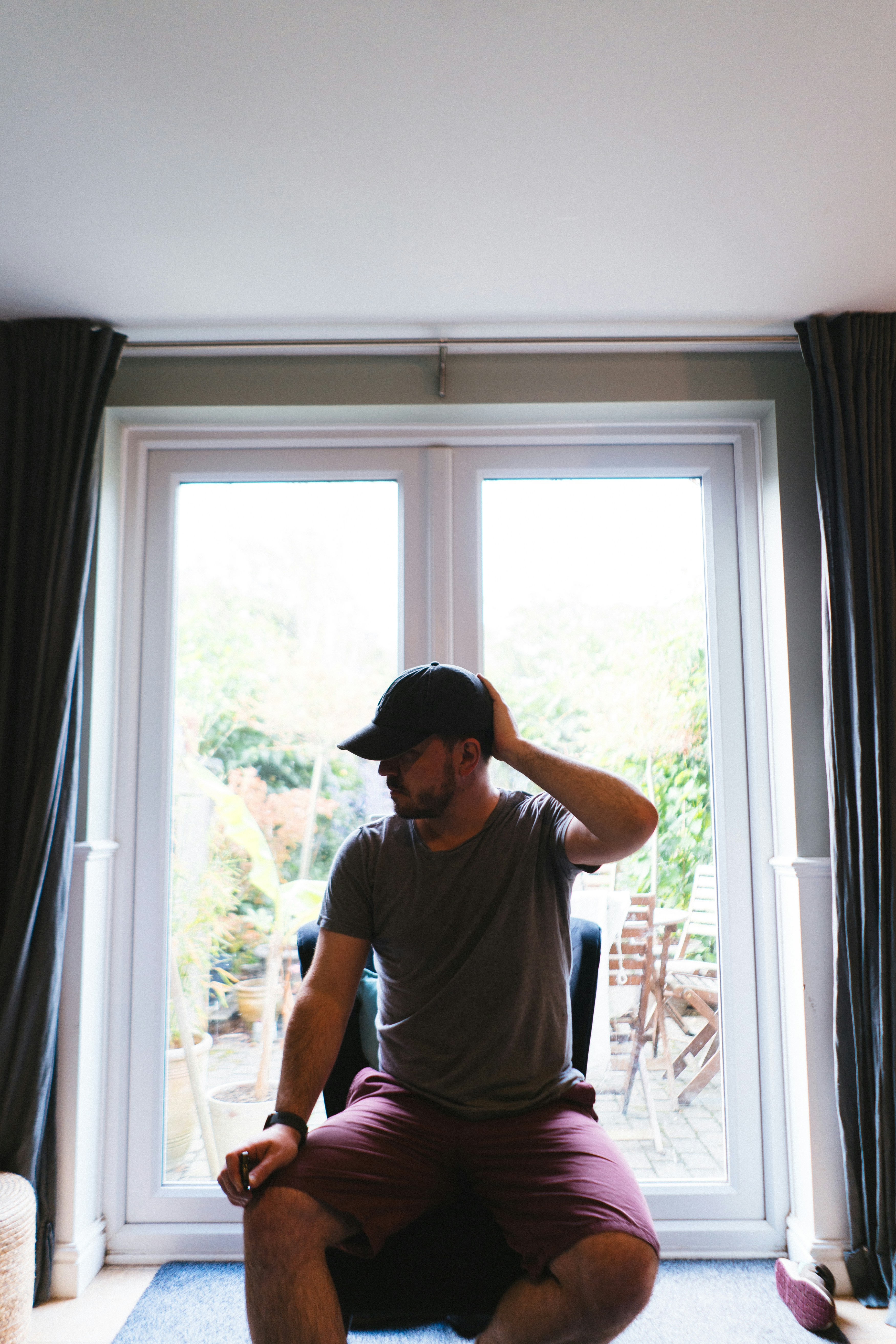 窓の前の床に座っている男性