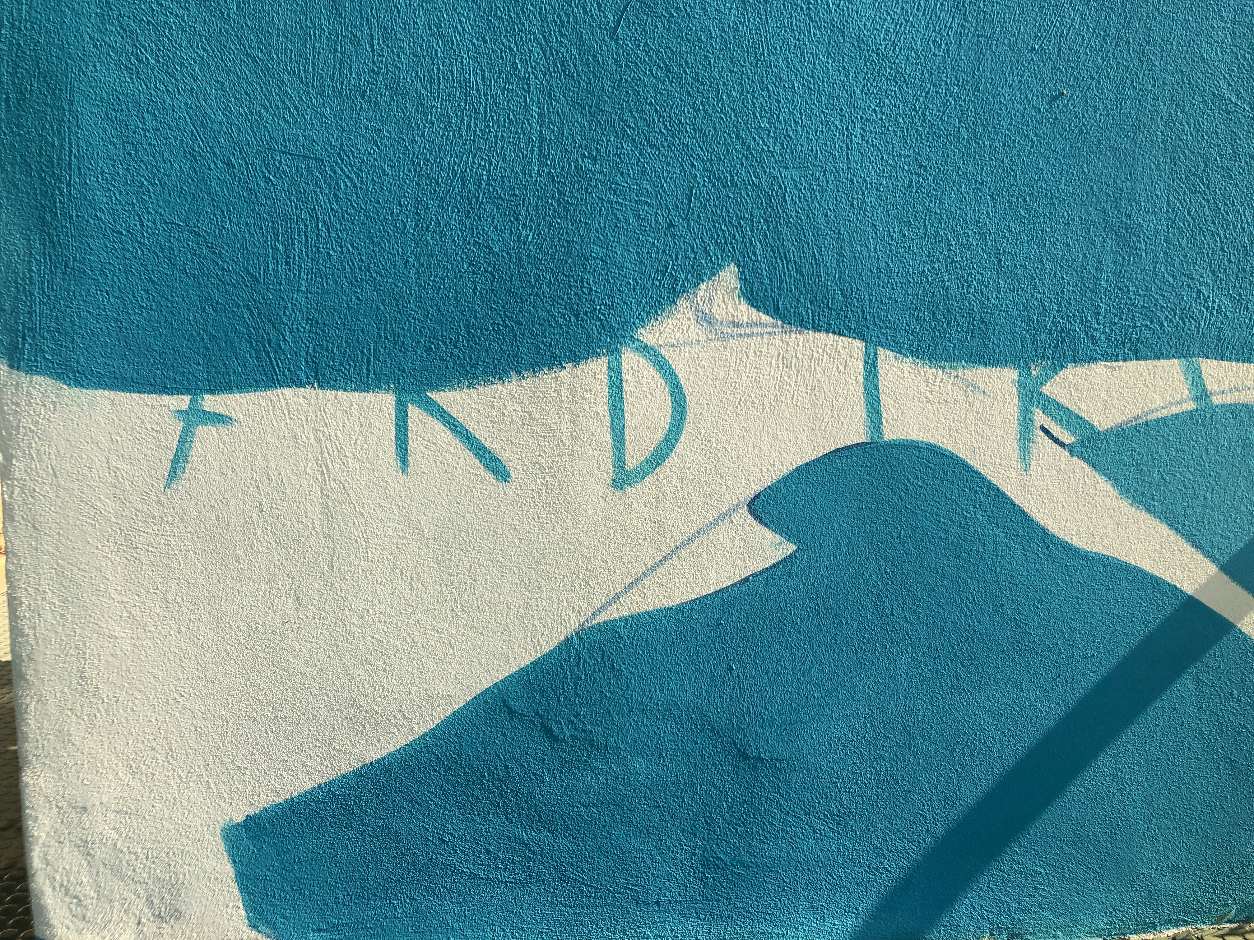Un muro dipinto di blu e bianco con un cane sopra