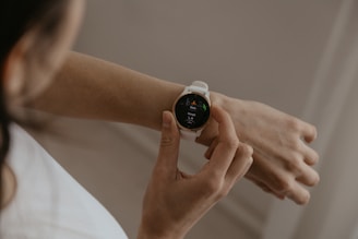 A woman holding a smart watch in her hand