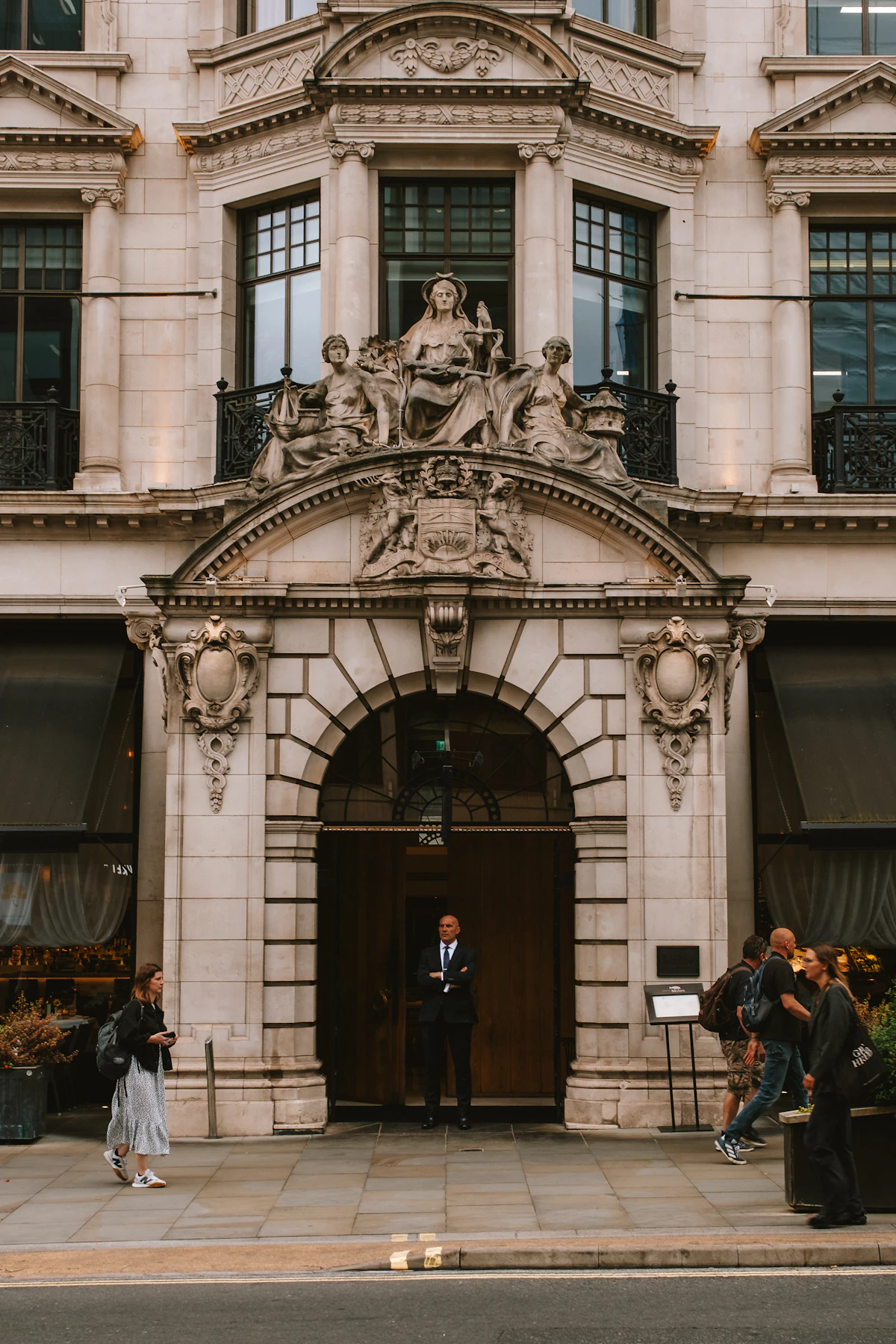 Agent en costume à l'entrée d'un immeuble de prestige