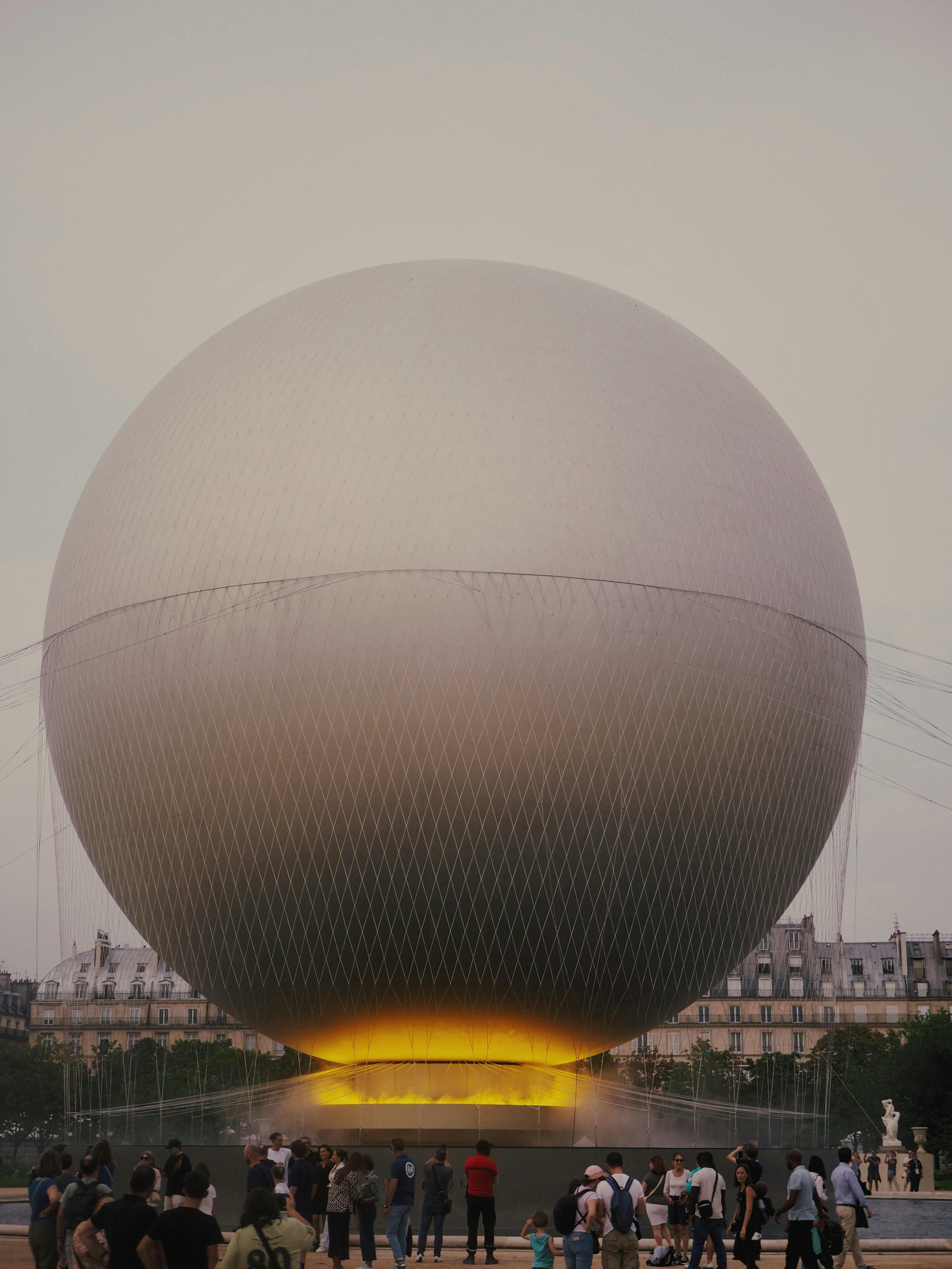 Un groupe de personnes debout devant une grande boule