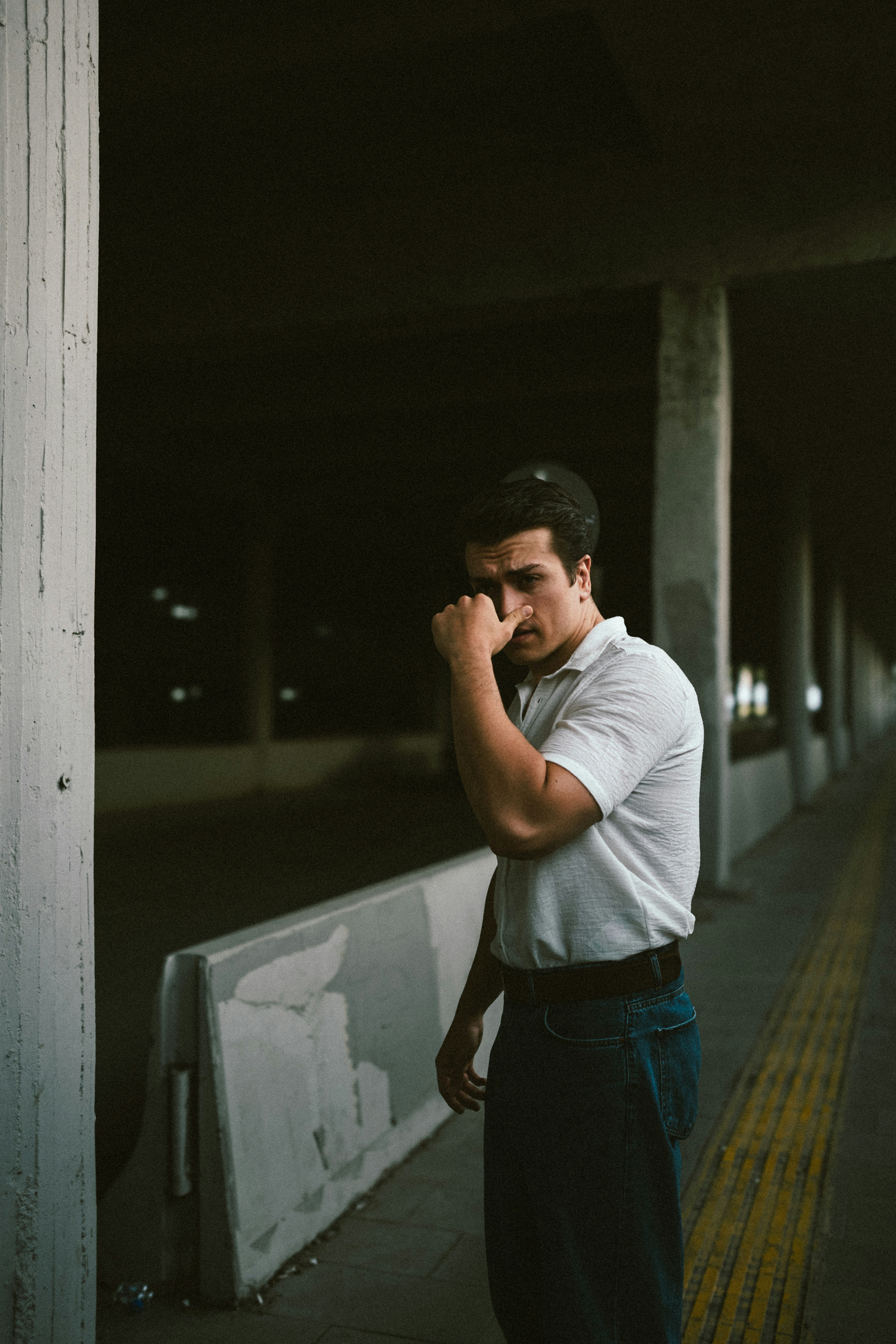 A man standing on a sidewalk talking on a cell phone