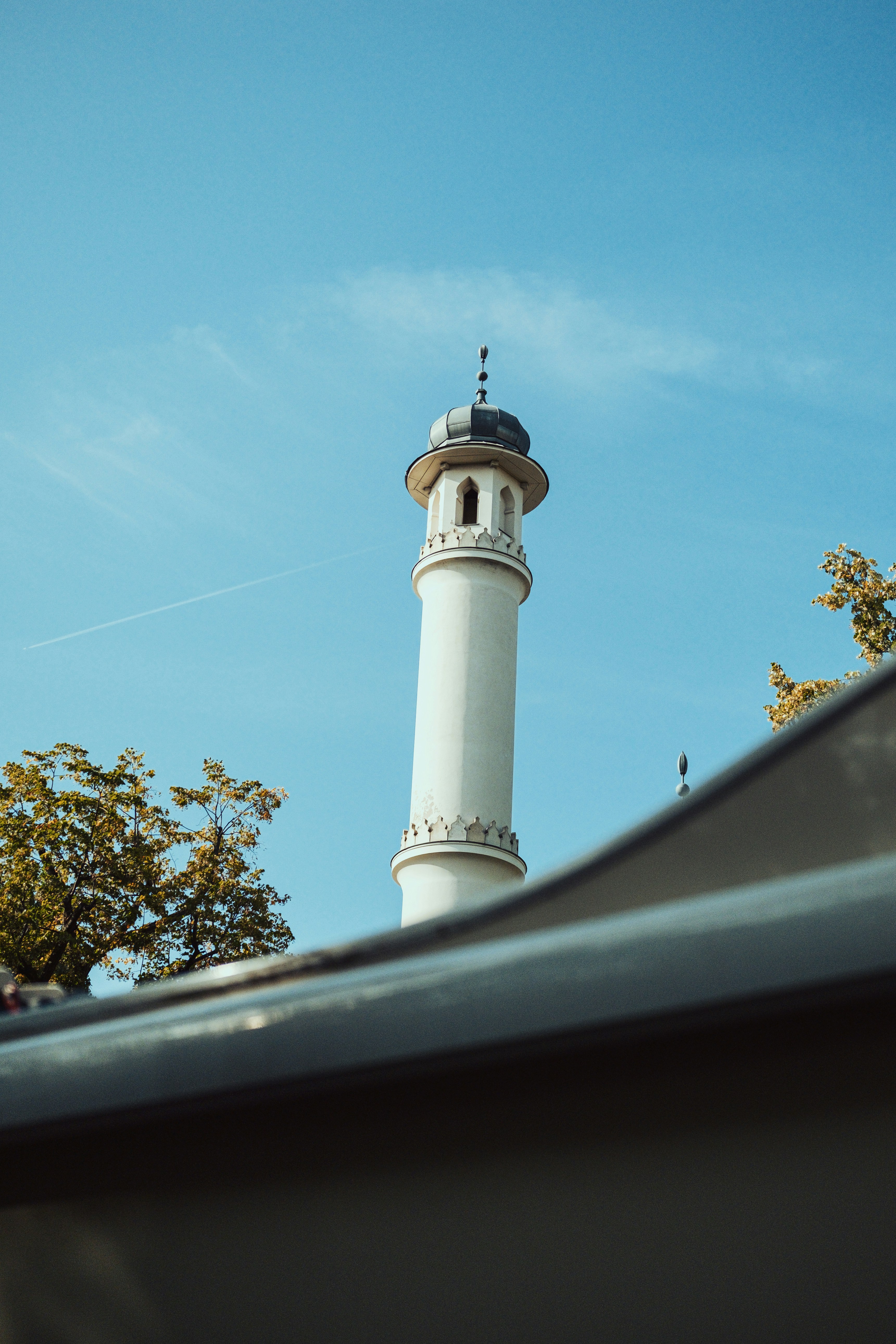 A tall white tower with a clock on it's side