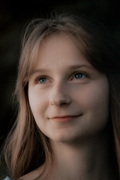 A woman with long hair and blue eyes smiling