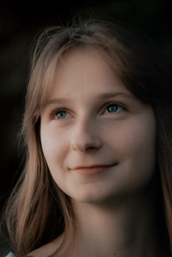 A woman with long hair and blue eyes smiling