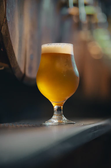 A glass of beer sitting on top of a table