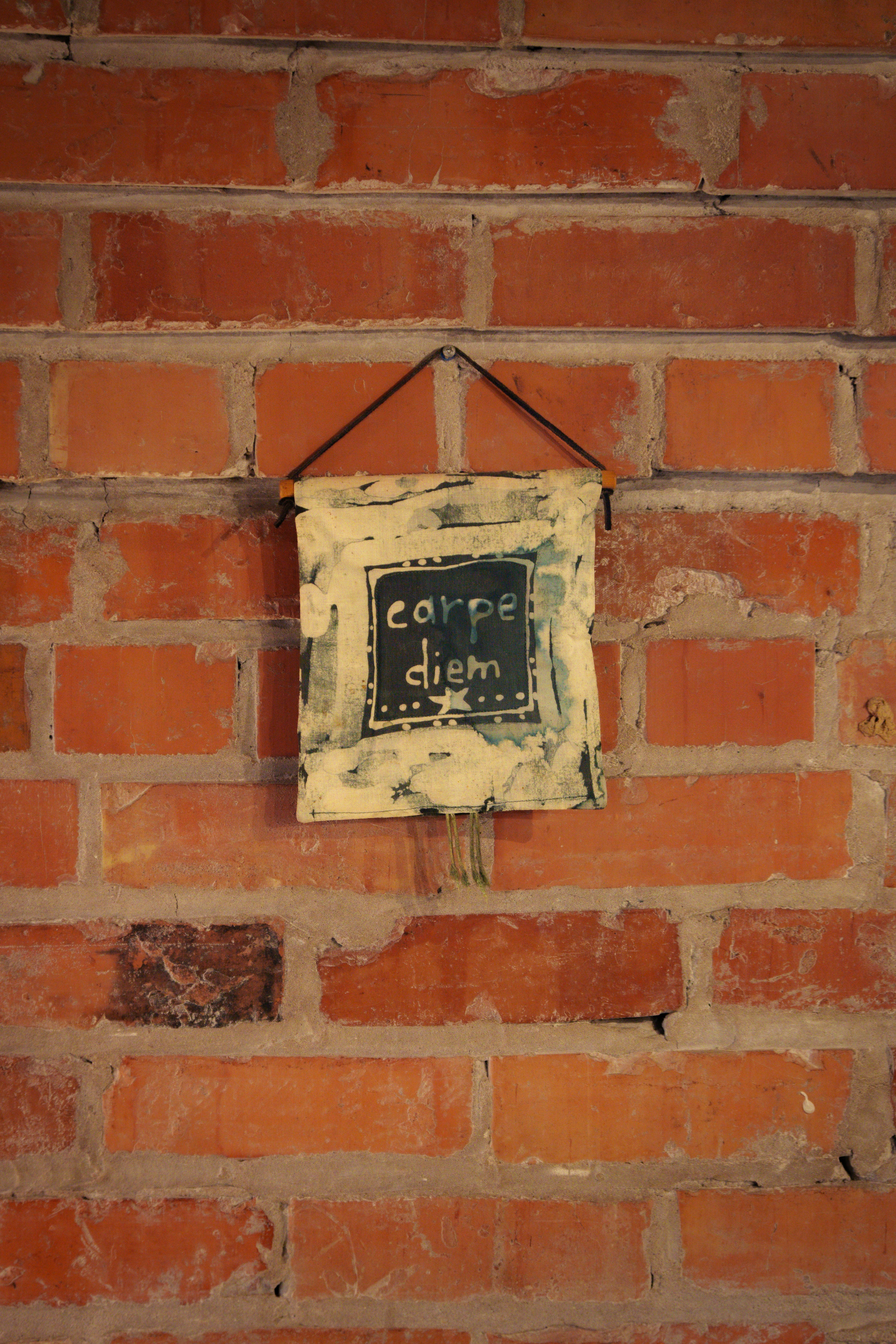 A brick wall with a sign hanging on it