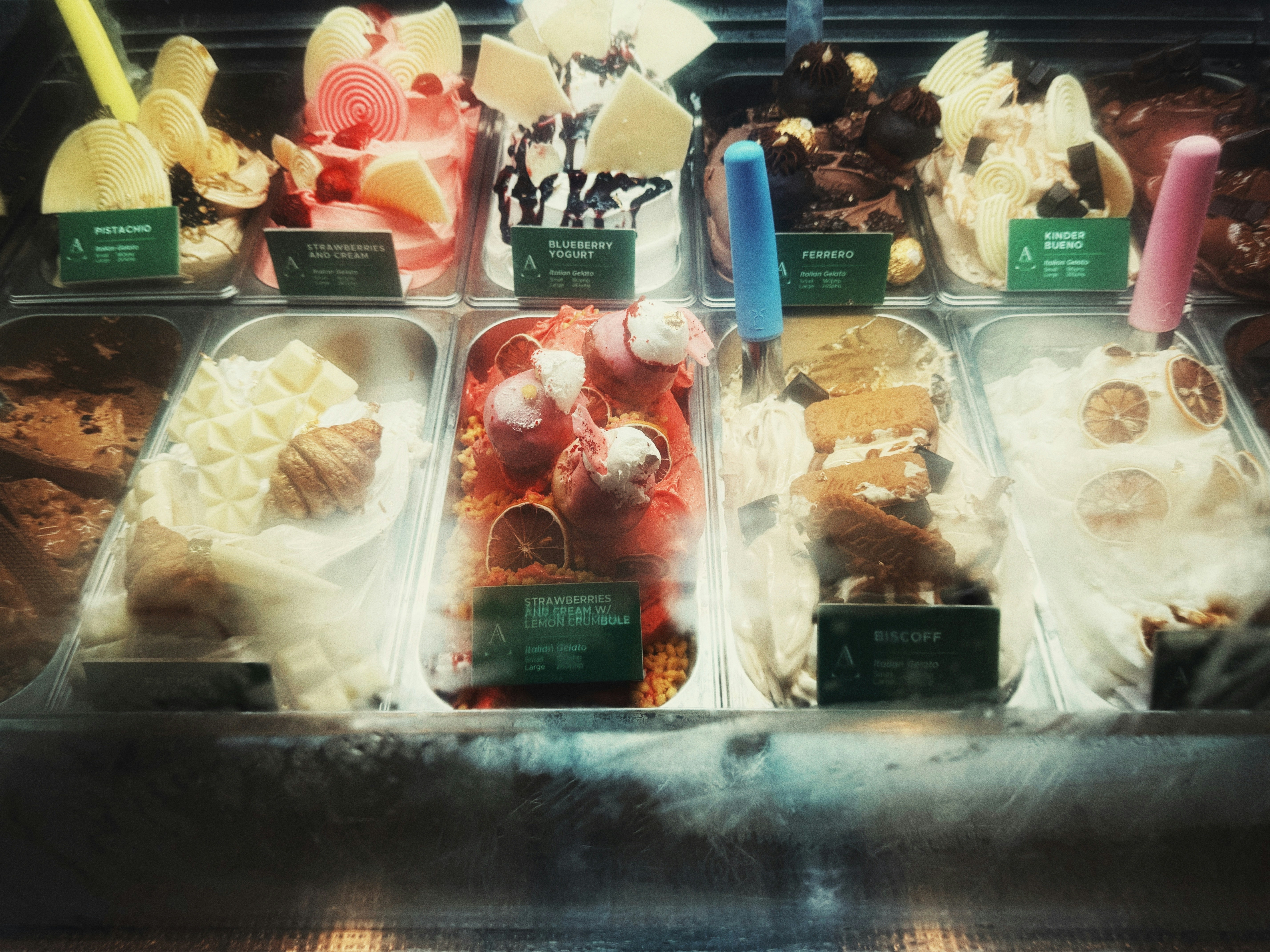 various colorful scoops of ice cream and gelato in a display case - best ice cream uptown