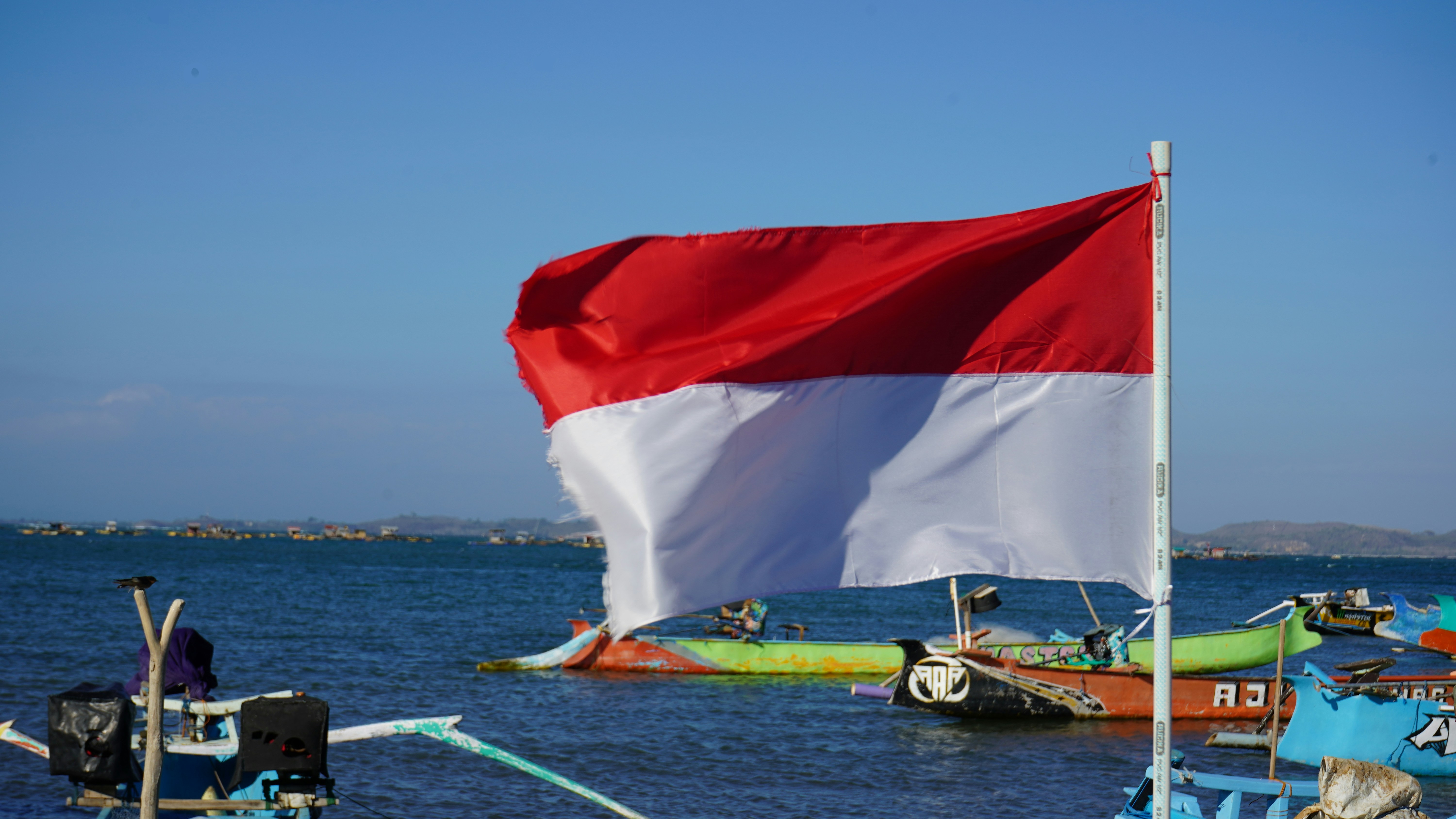 A boat with a flag on top of it in the water