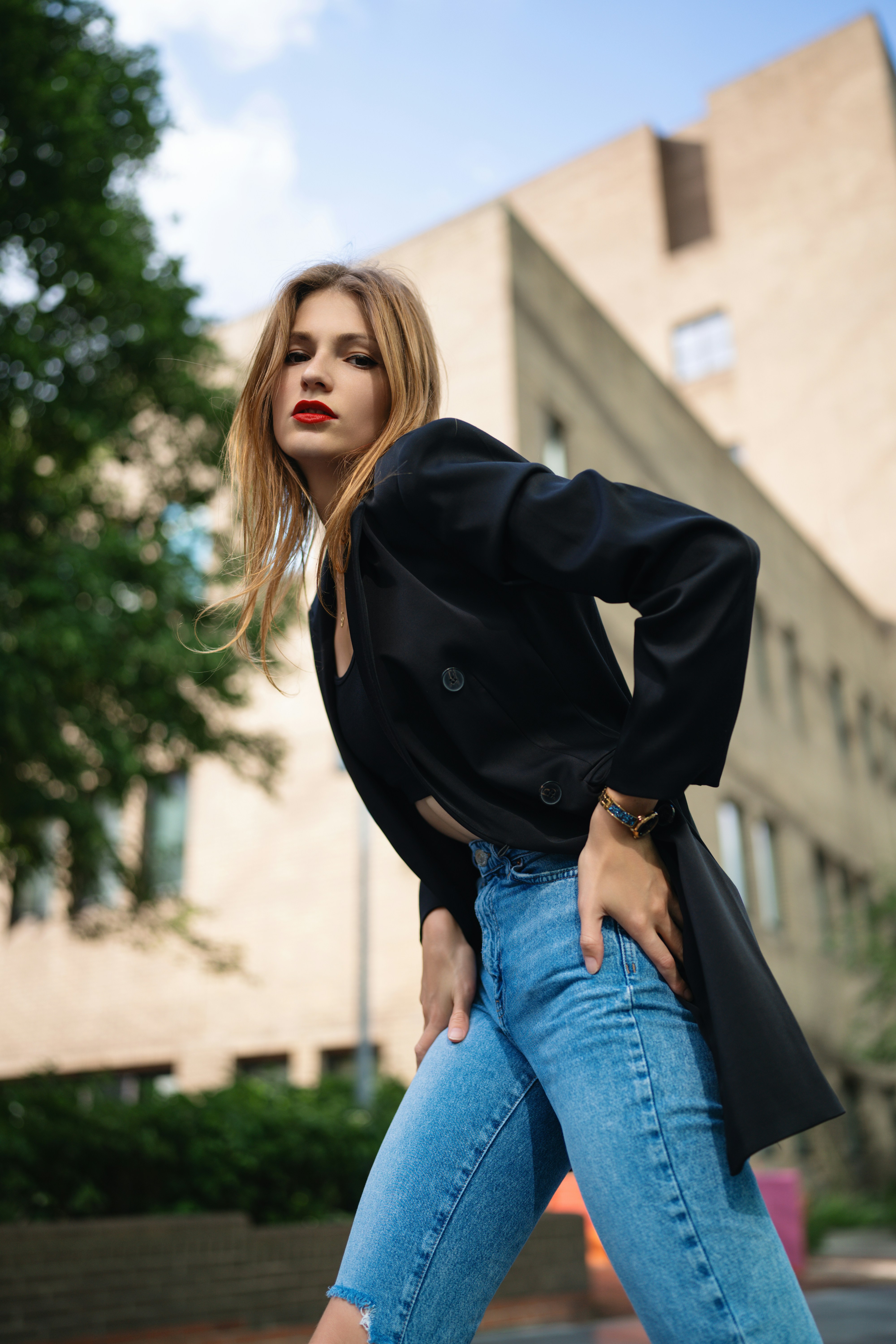 A woman in a black jacket and jeans posing for a picture