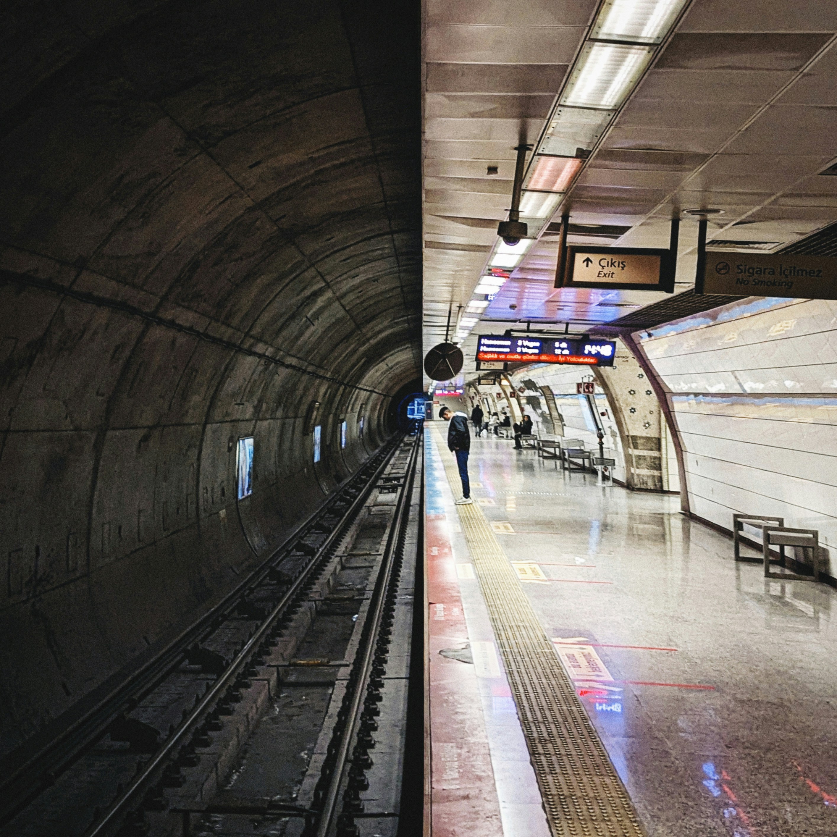 A subway station with a person walking on the platform