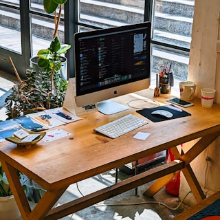 A wooden desk with a computer on top of it