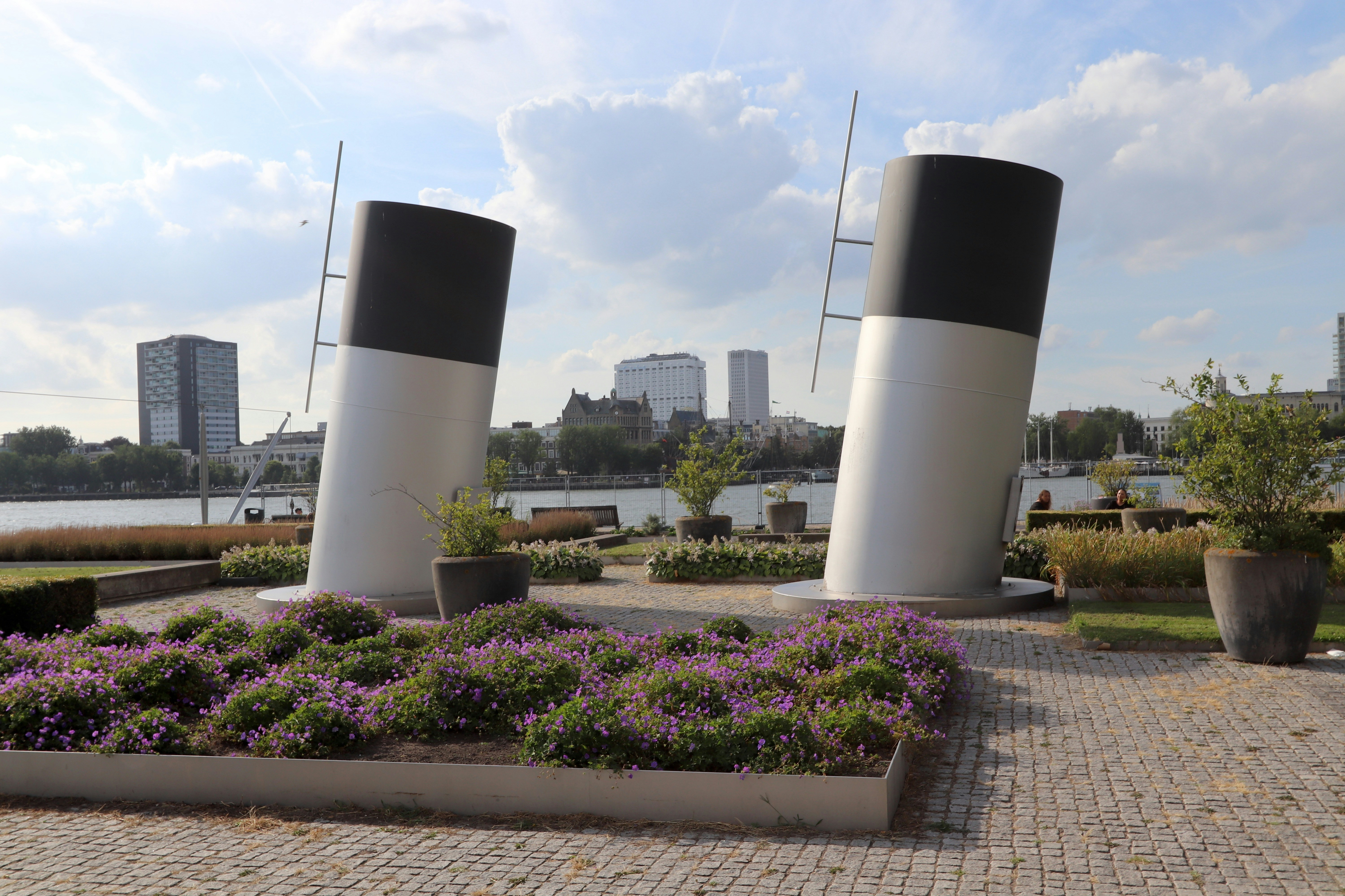 Tuin Rotterdam — A couple of large white and black vases sitting on top of a sidewalk — Tuinrenovatie in Rotterdam: bodem, kosten en lokale tips voo