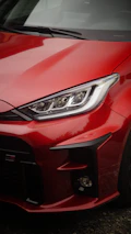 A close up of a red car parked in a parking lot