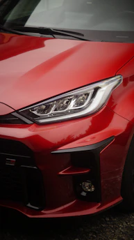 A close up of a red car parked in a parking lot