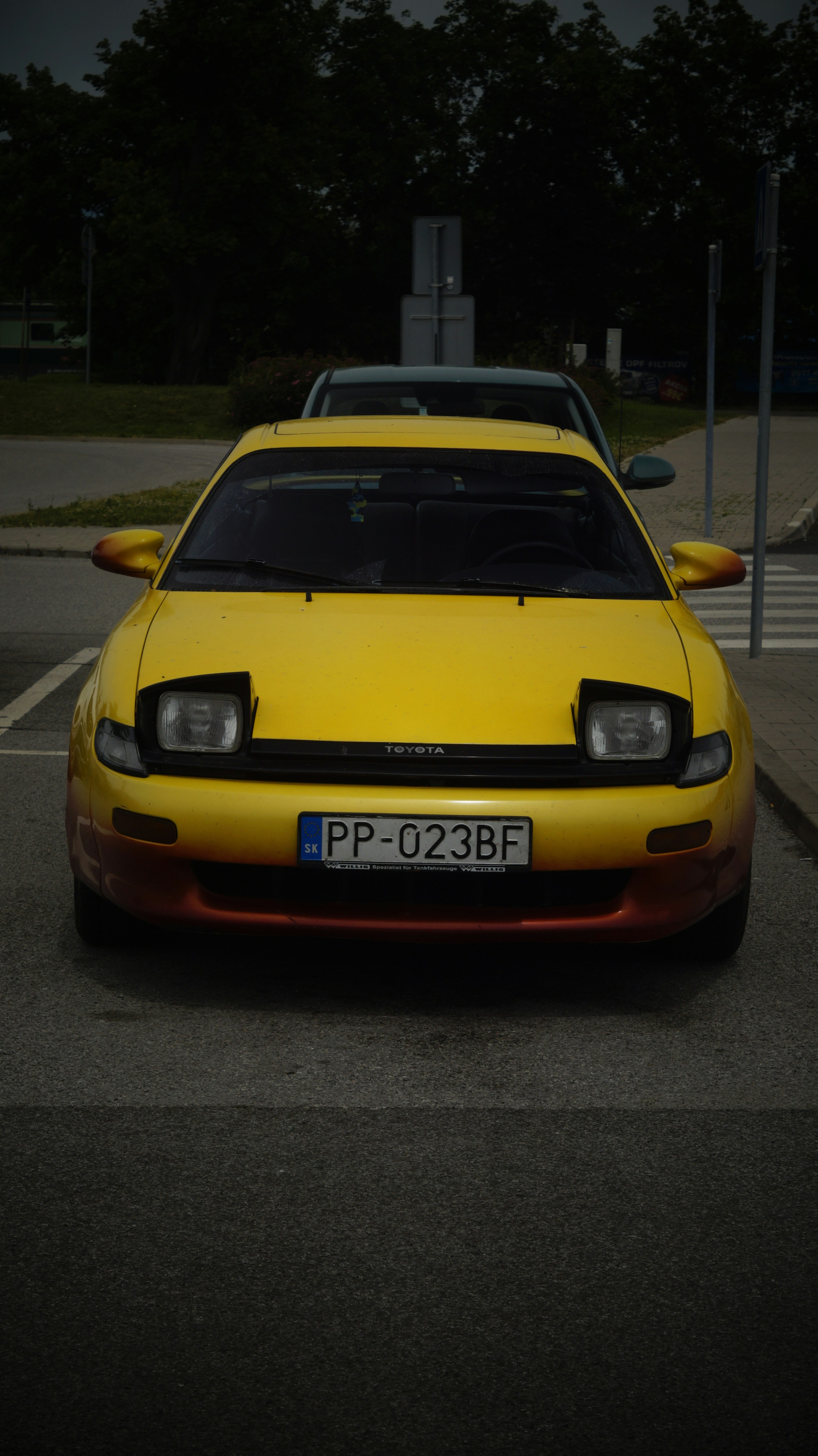 A yellow sports car parked in a parking lot