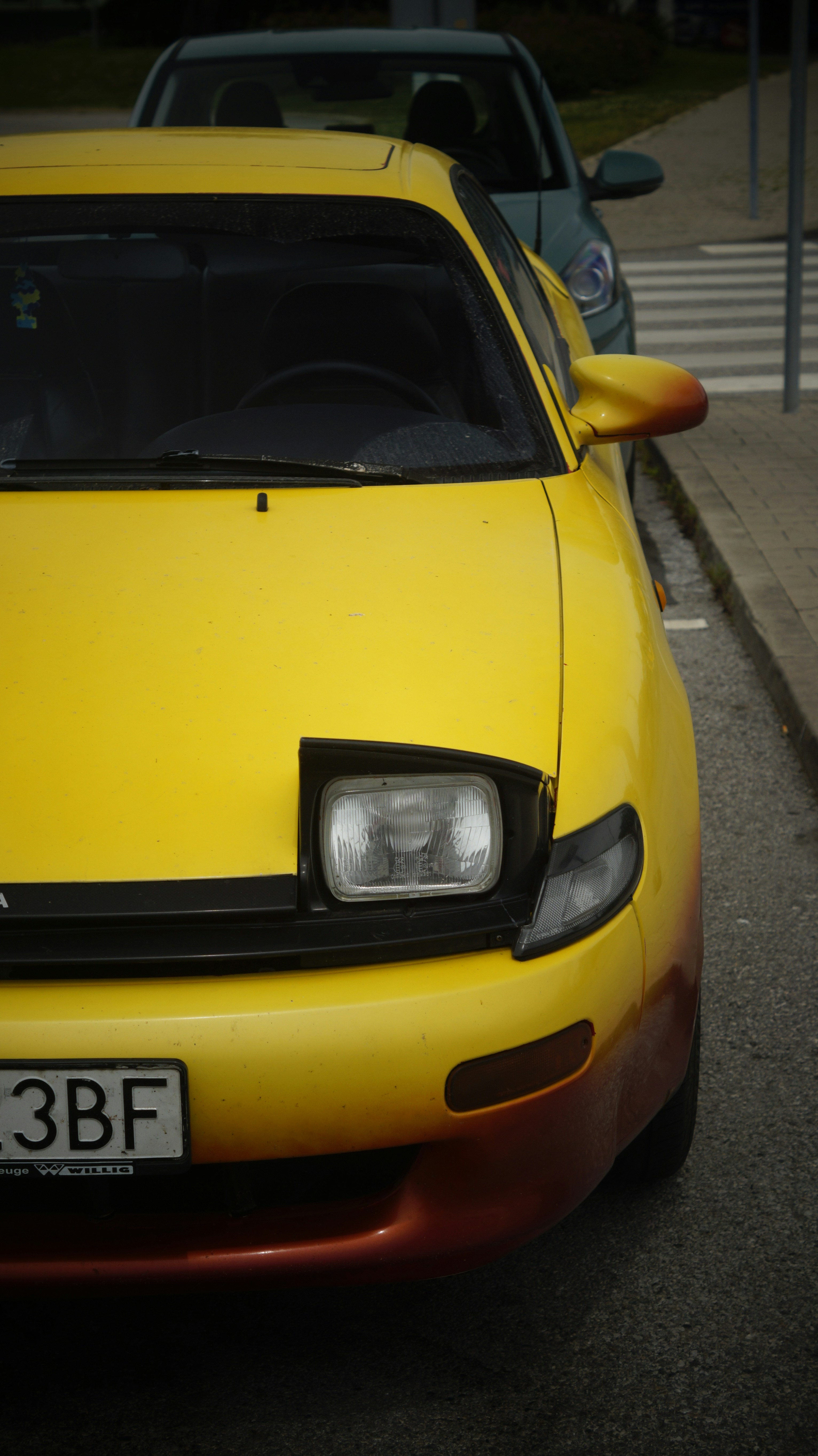 A yellow sports car parked on the side of the road
