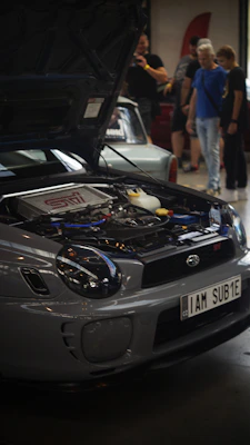 A car with its hood open in a showroom