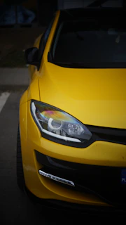 A yellow car parked in a parking lot
