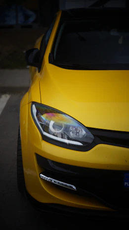 A yellow car parked in a parking lot