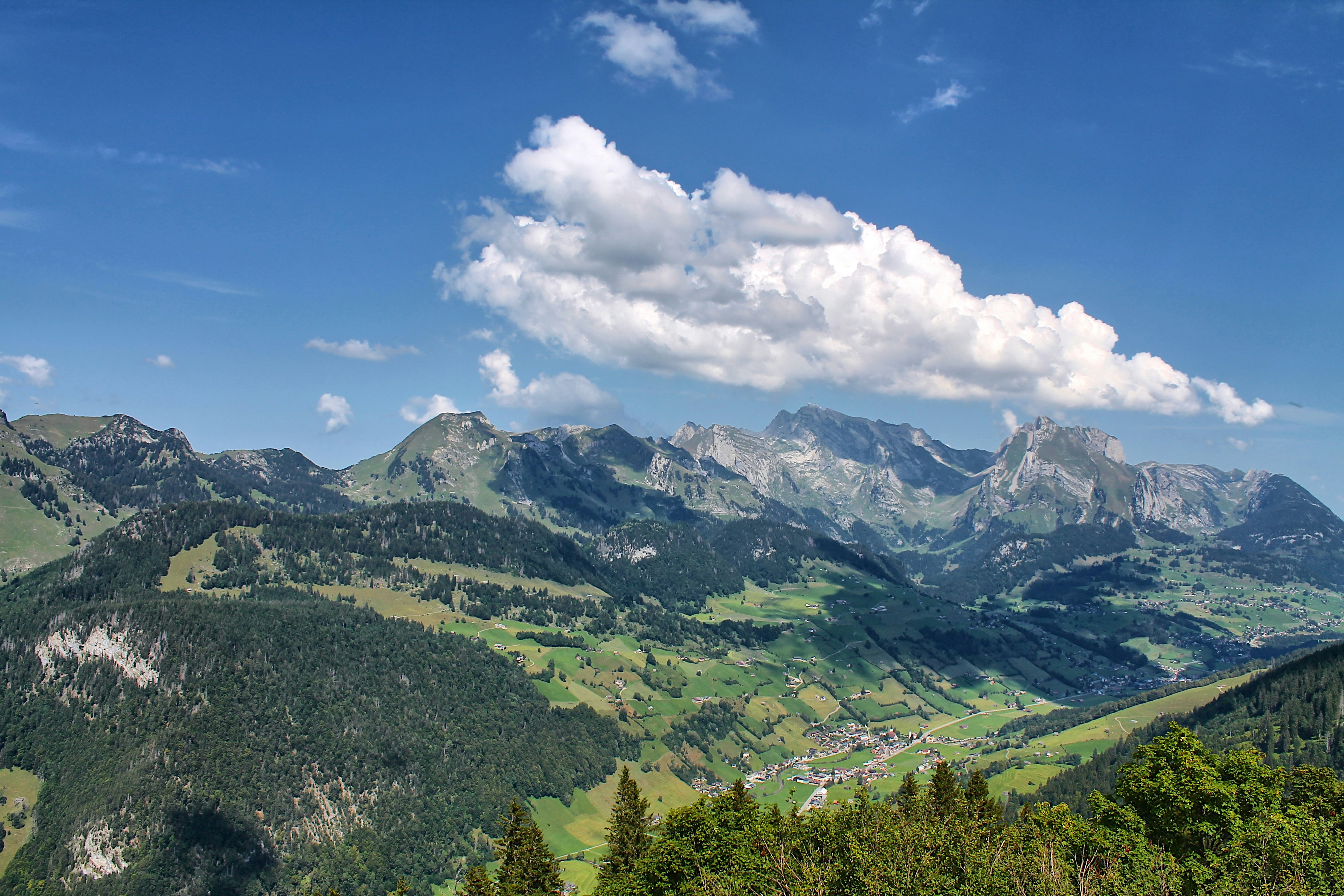 A scenic view of a mountain range with trees and mountains in the background