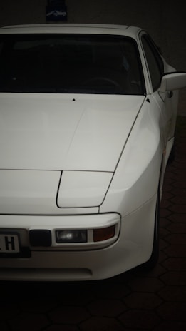 A white car parked in a driveway at night