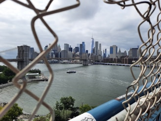 A view of a city from behind a chain link fence