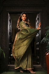 A woman in a green dress standing in a doorway