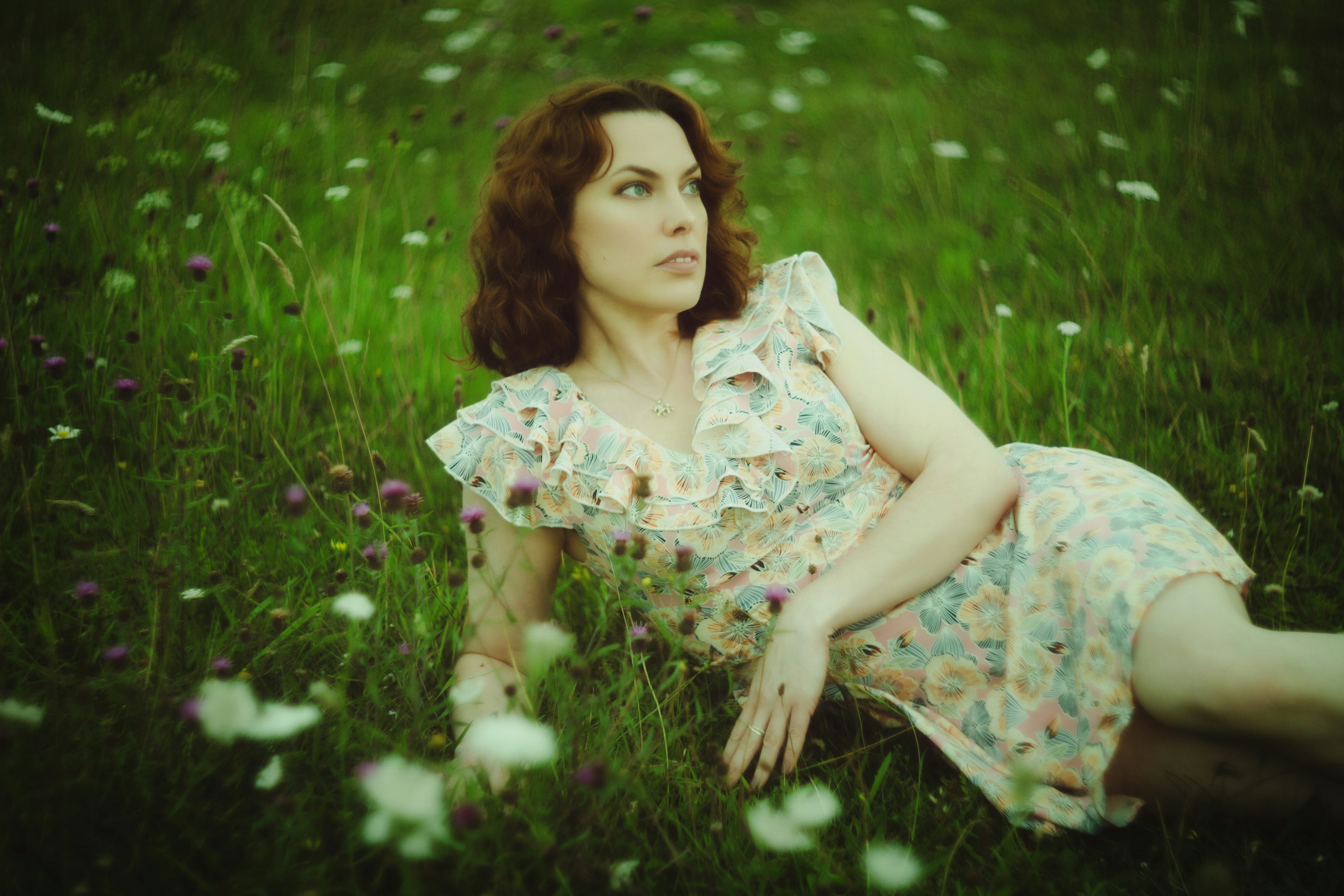 A woman laying on the ground in a field of flowers