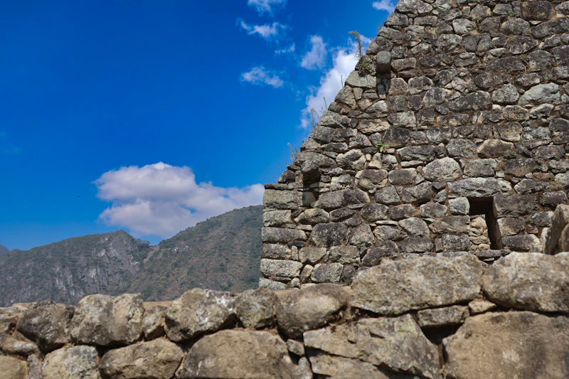 A drystone Inca building wall at Machu Picchu against a deep blue sky