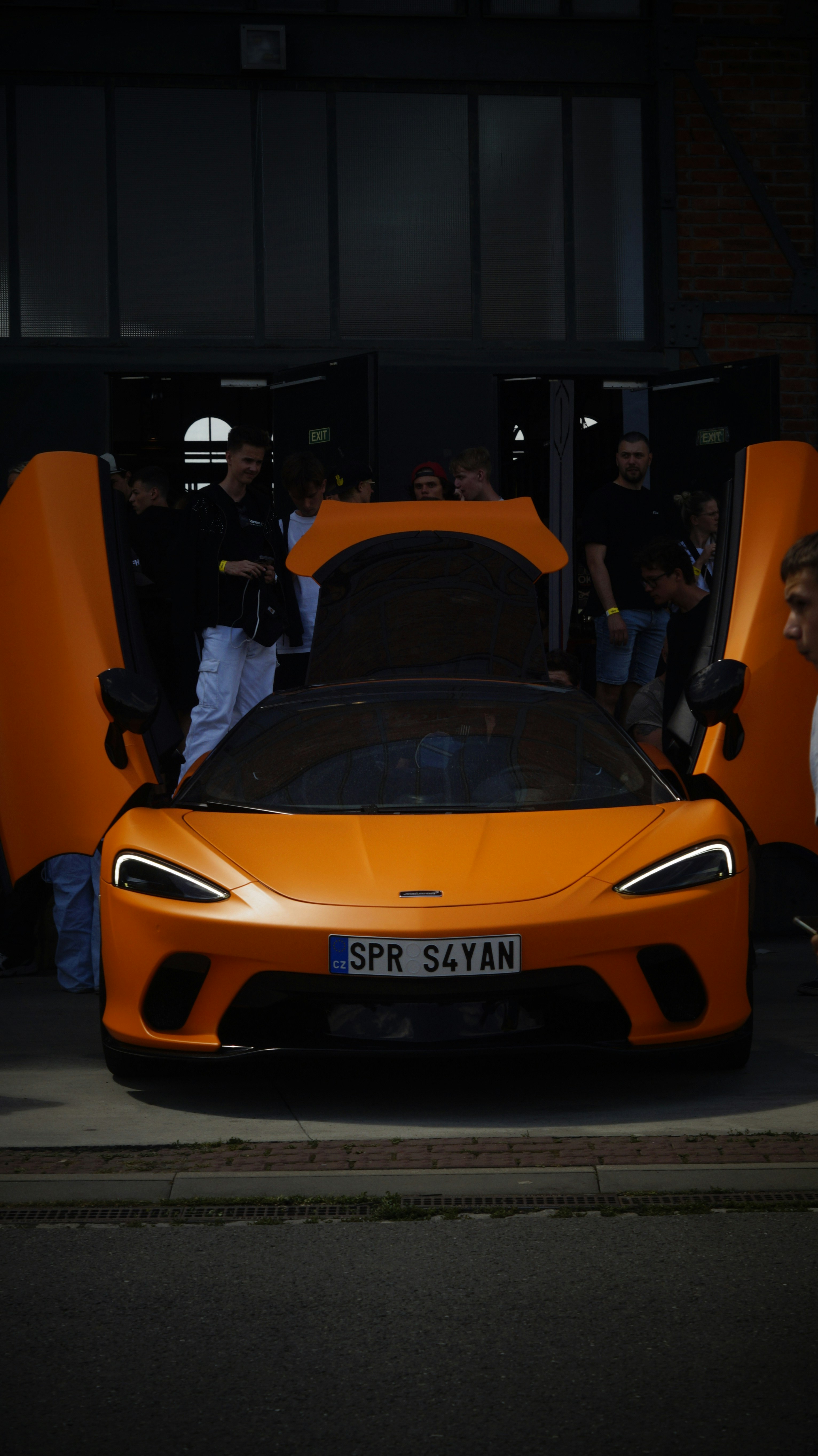 An orange sports car parked in front of a building