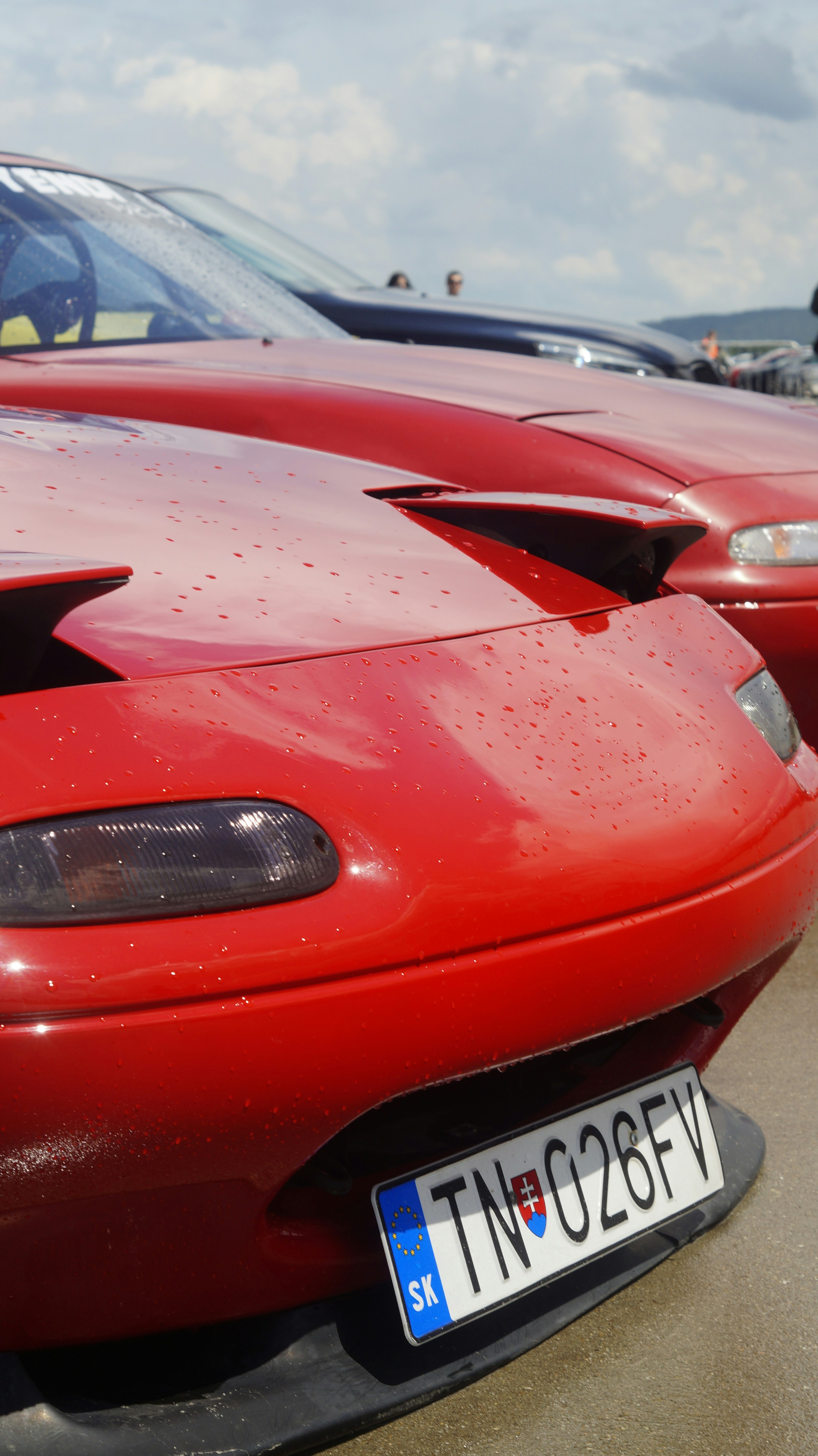 A red sports car parked in a parking lot