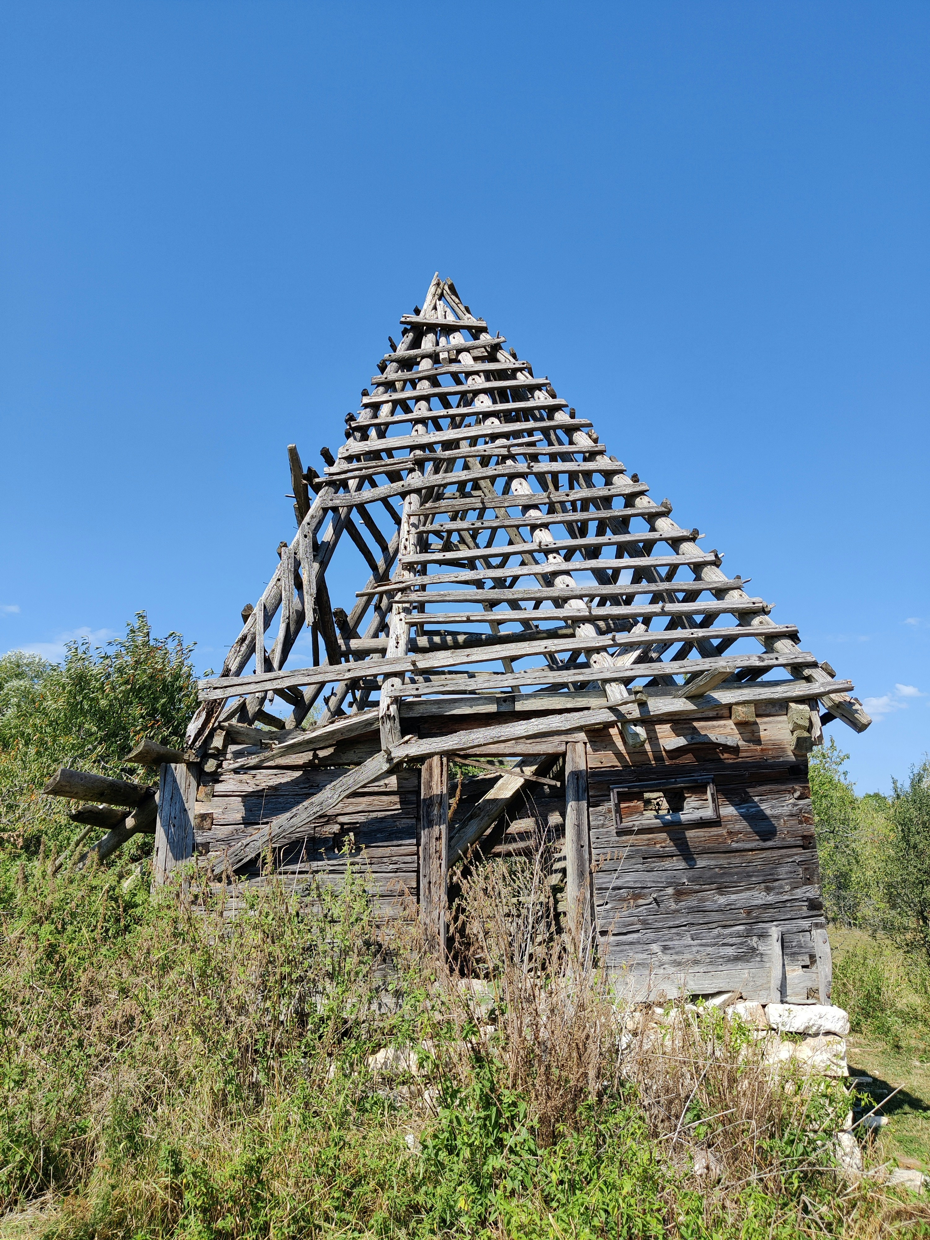 An old wooden building with a roof made of wooden planks