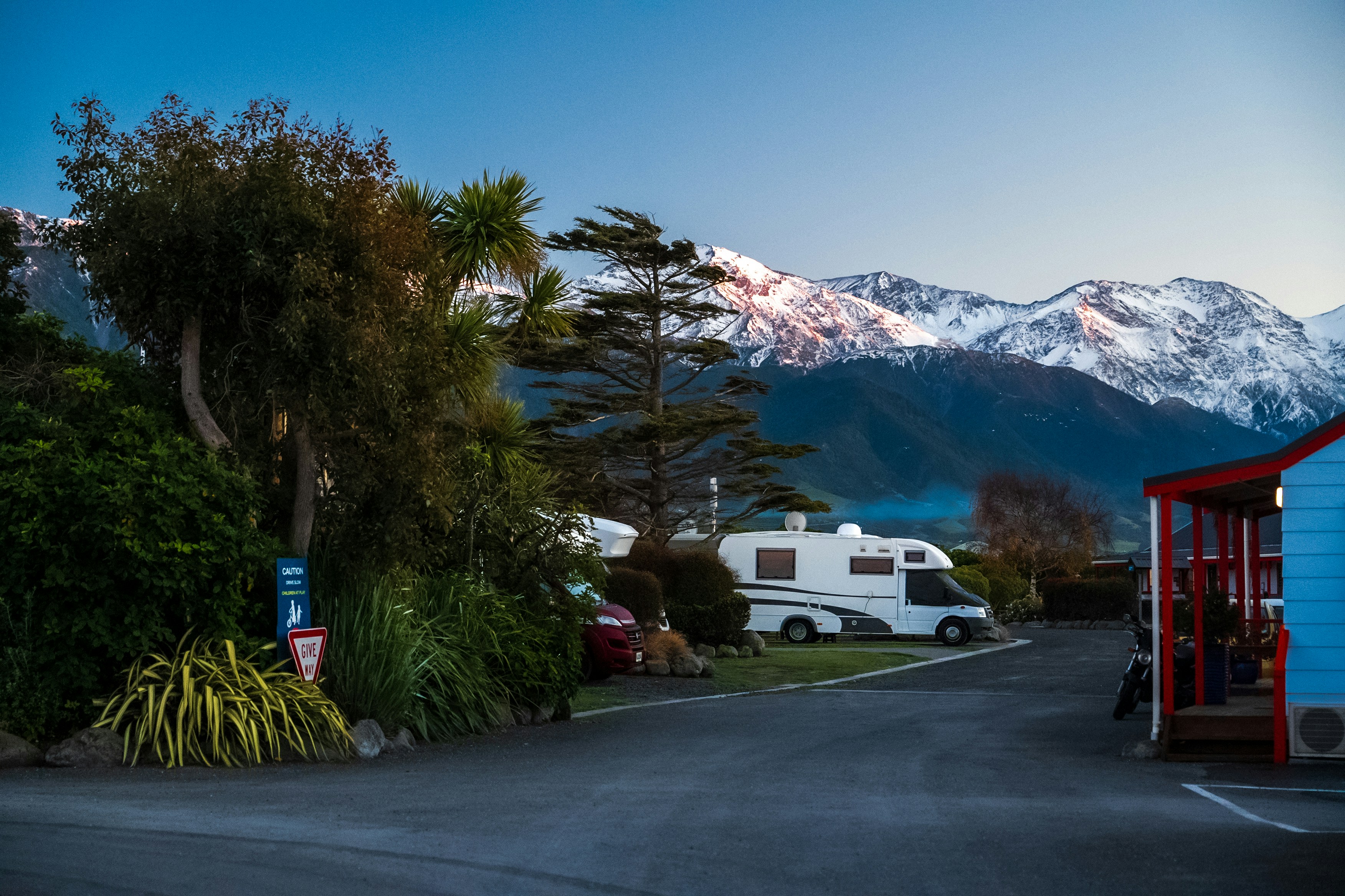 A small blue building sitting on the side of a road