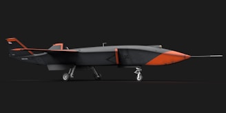 An orange and black airplane on a black background